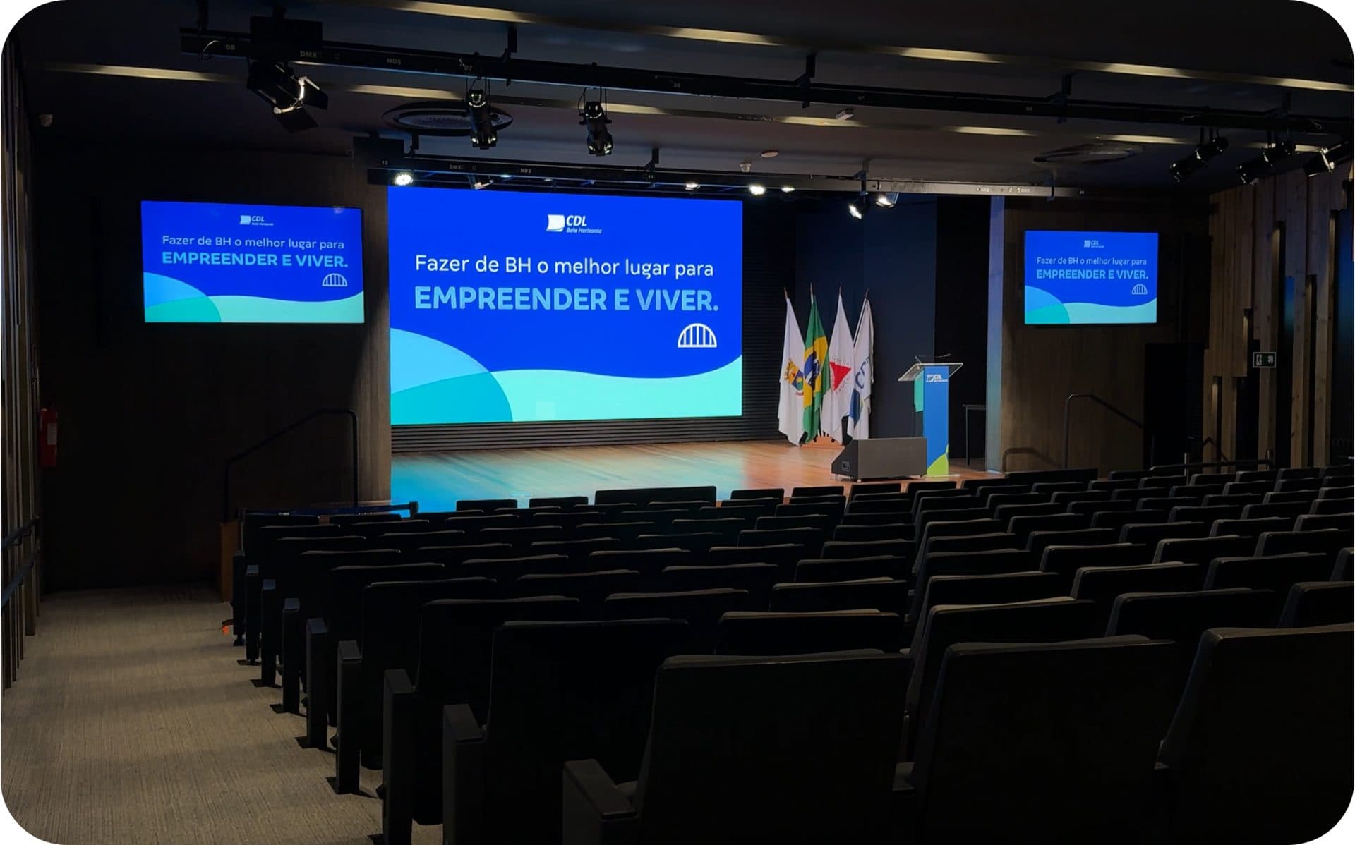 Plateia do auditório com as poltronas fixas e o palco ao fundo